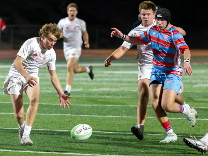 Cathedral Catholic, in white, chasing a loose ball vs Charlotte Catholic. Photo Dan Caple.