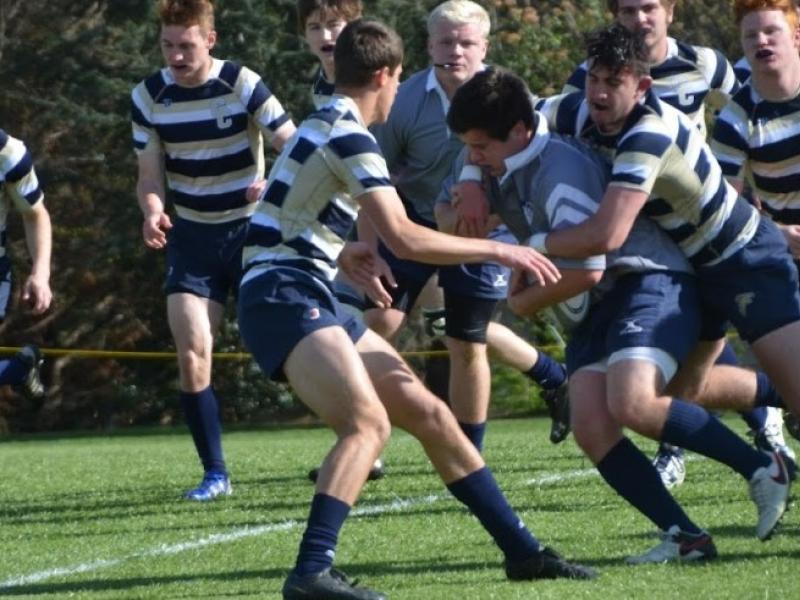 prop reily barlett carries the ball and a gc defender for prep