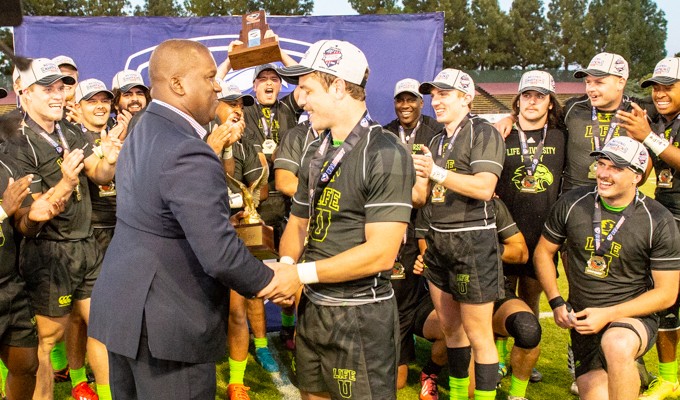 Kevin Battle presenting Life University's Ryan Rees with the D1A Final MVP award in May, 2019. David Barpal photo.