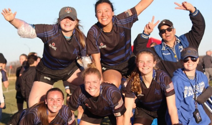 A pyramid of Air Force women's rugby players celebrate victory.