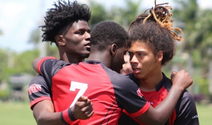 VaShon Mars, Tony Robinson, and Andre Butler hug it out for the Wolverines.