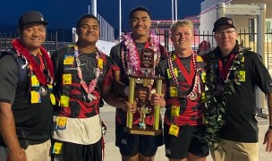 Cavemen players and coaches with their trophy.