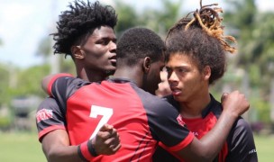 VaShon Mars, Tony Robinson, and Andre Butler hug it out for the Wolverines.