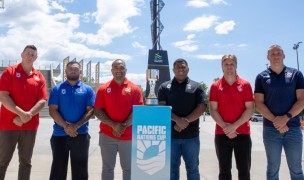 Representatives from the six PNC nations, including Matt Jensen at right, pose with the trophy at America First Field. 