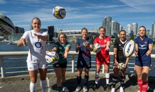 Kate Zackary, in blue in the middle, with the other WXV 1 captains in front of BC Place and the Vancouver skyline. 