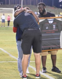 CJ Hopper's brother and mother receive a framed jersey from the Belmont Abbey team.