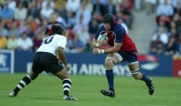 Dave Hodges challenges a Fijian defender during the 2003 Rugby World Cup. Photo Rugby World Cup.
