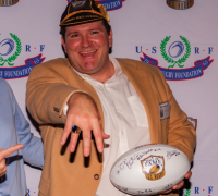 2021 Hall of Fame inductee Mike MacDonald shows off his HOF cap and a championship ring.
